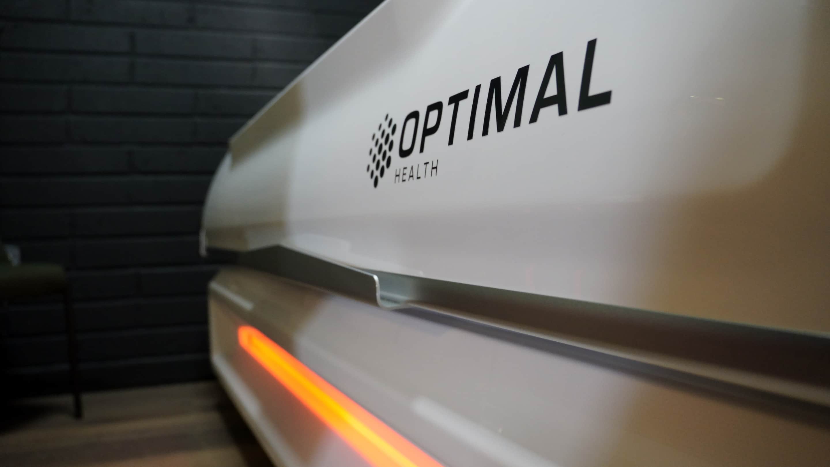 Close along the shell of the infrared bed at the Clonmel clinic, its orange strip lit against black brick