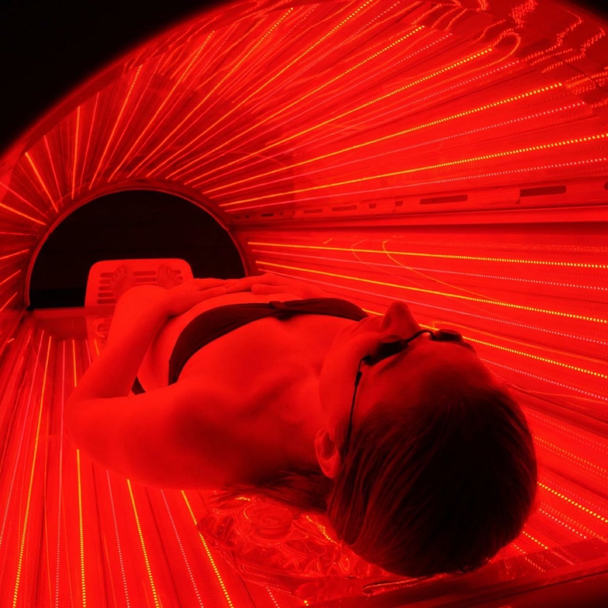Inside the infrared bed, looking along the LED array, a client lying under eye protection