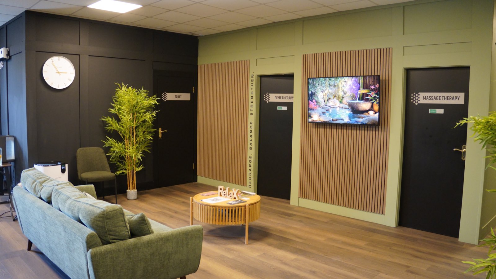 The waiting area at the Clonmel clinic, its treatment-room doors and the wall screen